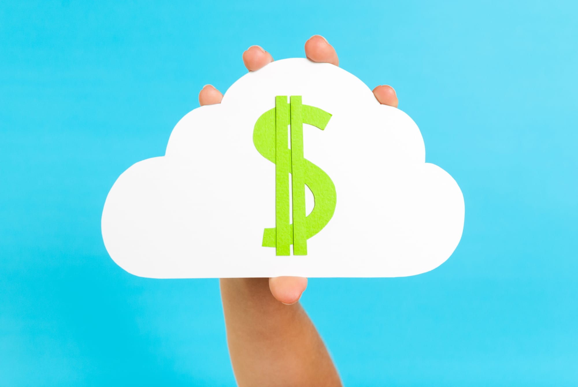 Hand holding a cloud with a dollar sign symbolizing costs related to cloud computing.